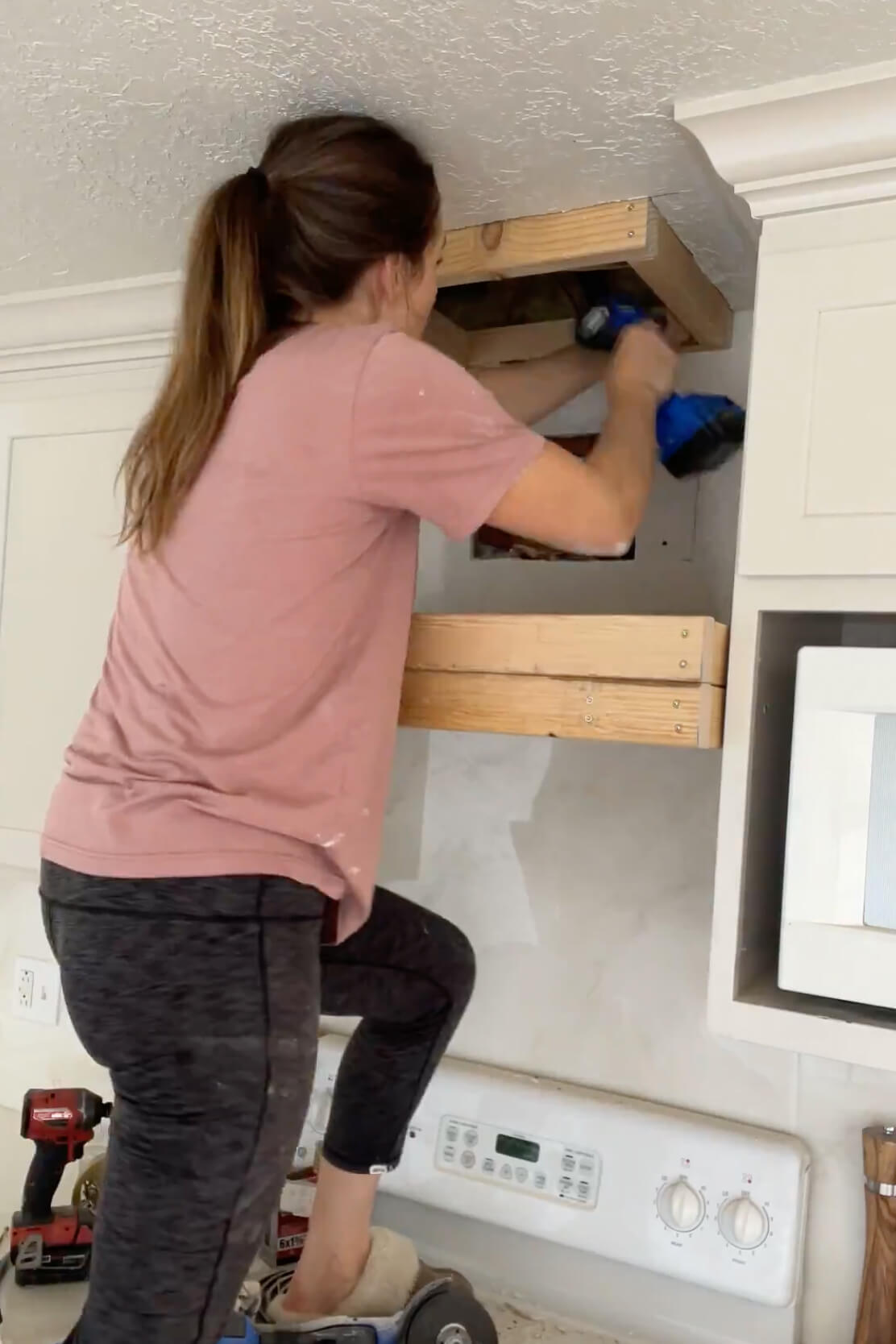 Framing a DIY range hood cover during a budget kitchen remodel.